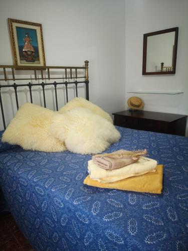a bed with two pillows and towels on it at Posada del Sol in Gaucín