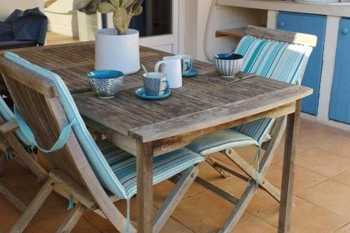 une table en bois avec des bols bleus et des tasses dessus dans l'établissement Maison Vigneronne de caractère du XIX plein centre, à Marseillan