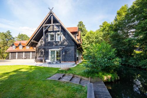 an old house with a gambrel roof and a river at Spreewald Chalet in Burg