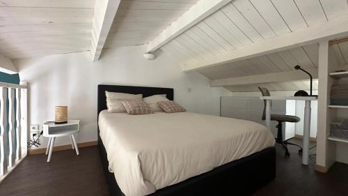 une chambre avec un grand lit et un bureau dans l'établissement T1 bis Duplex 500m de la plage, à La Rochelle