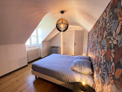 - une chambre avec un lit et un mur orné d'une fresque murale dans l'établissement Triplex - Au cœur de Fougères, à Fougères