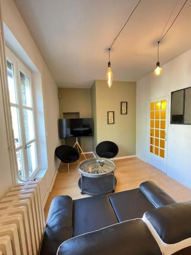 un salon avec un canapé et une table dans l'établissement Triplex - Au cœur de Fougères, à Fougères