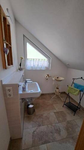 baño con lavabo, bañera y ventana en Fewo bei Reuters - Haus Tellkoppe, en Waldidylle
