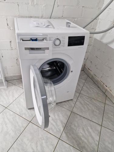 a white washing machine with its door open in a room at Ferienhaus Schwerte Ergste im Ruhrtal in Schwerte