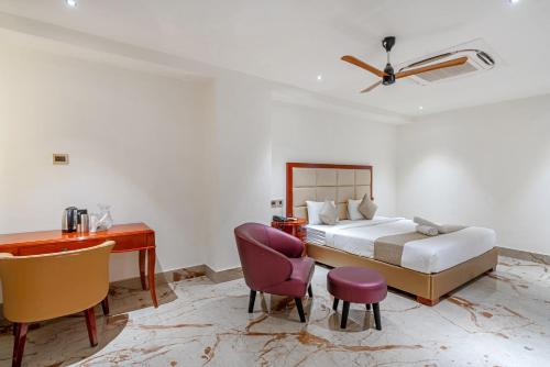 a hotel room with a bed and a desk and a desk at Hotel Chutneys in Hyderabad