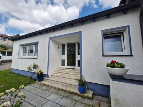 a white house with blue trim and stairs at Ferienhaus Schwerte Ergste im Ruhrtal in Schwerte