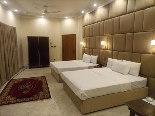 two beds in a hotel room with two beds sidx sidx sidx at R.M RESIDENCY in Lahore