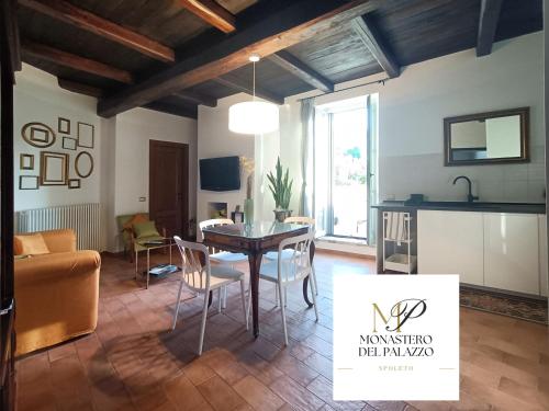a kitchen and living room with a table and chairs at Monastero Del Palazzo Casa Vacanze in Spoleto