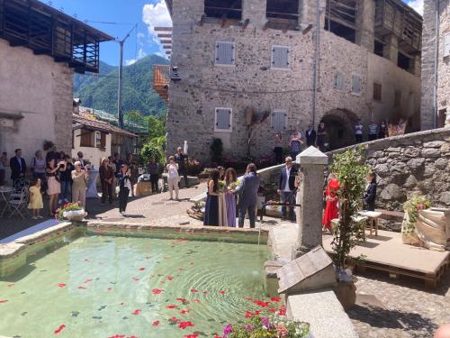 a group of people standing around a fountain in front of a building at IL moleta Affittacamere in Balbido-rango