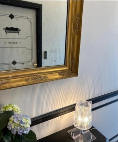 a mirror and a vase of flowers on a table at Maison du Roi in Liège