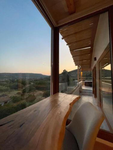 a room with a wooden table and a large window at Serenity in Samos