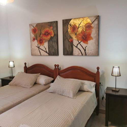 two beds in a bedroom with three paintings on the wall at Los Padres C in Tijarafe