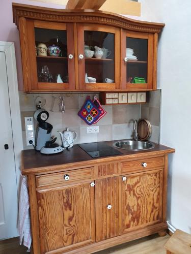 a kitchen with a sink and a wooden cabinet at Garten-Pause in Elstal