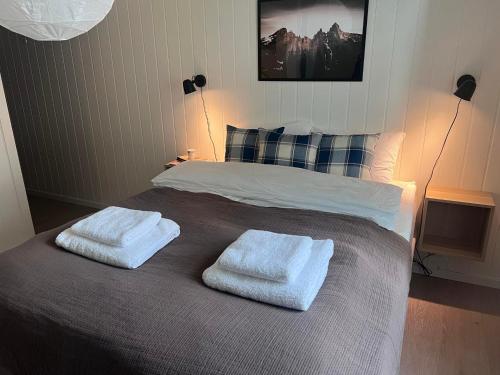 a bedroom with a bed with two towels on it at Koselig leilighet i Ålesund sentrum in Ålesund