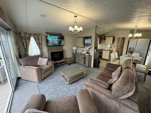 a living room with two couches and a tv at Golden Palm Resort - The Superior Retreat - Coastal Caravan Breaks in Chapel Saint Leonards