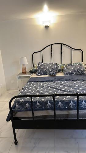 un letto nero con cuscini sopra di Chambre confortable a Limay