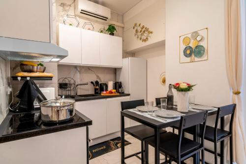 une petite cuisine avec une table et des chaises noires dans l'établissement Splendide, refait à neuf, climatisé, plage à 1mn- 