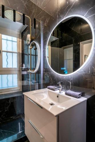 une salle de bain avec un lavabo et un miroir dans l'établissement Splendide, refait à neuf, climatisé, plage à 1mn- 