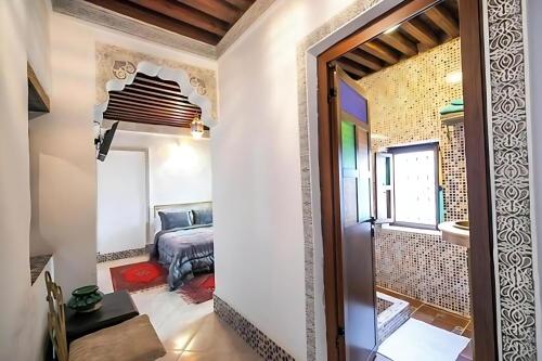 a hallway with a door leading into a room with a bed at Riad Mounana fez luxurious palace & spa in Fès