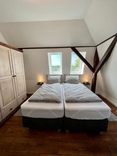 a bedroom with a large bed with two windows at Wohnung im Schloss in Todendorf