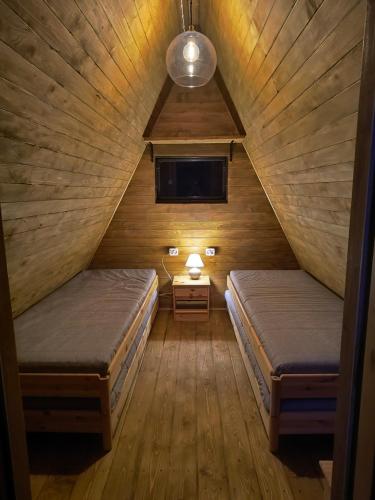 a attic room with two beds and a window at Moto Keja Bieszczady in Uherce Mineralne (7)