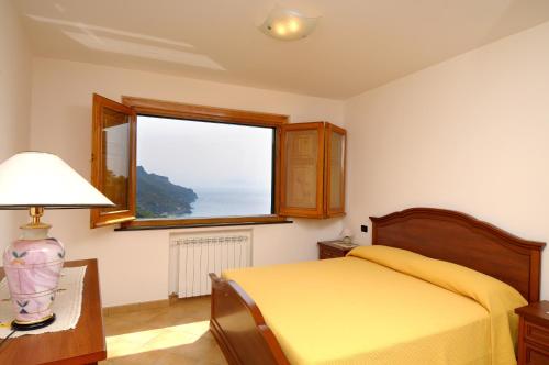 a bedroom with a yellow bed and a window at Casa Rossa in Ravello