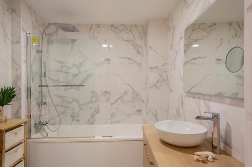 une salle de bain blanche avec un lavabo et une douche dans l'établissement Le Lacydon, appart 8 pers, 2 minutes du Vieux Port emplacement exceptionnel, à Marseille