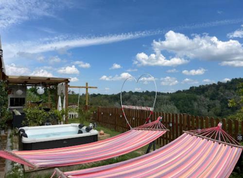two hammocks in a yard with a bath tub at B&B TERRA DI COLLINA in Montegrosso dʼAsti