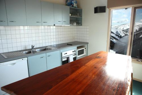 a kitchen with a wooden table and a counter top at Timbertop in Mount Hotham