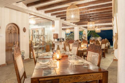 a dining room with a large wooden table and chairs at Waterlovers Beach Resort in Diani Beach