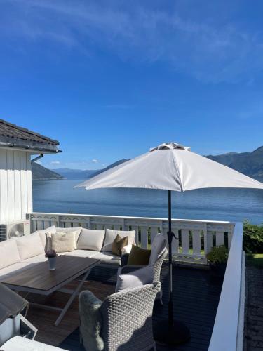 a patio with a couch and an umbrella at Fjordhus in Austerheim