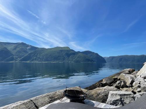 a boat sitting on the shore of a body of water at Fjordhus in Austerheim
