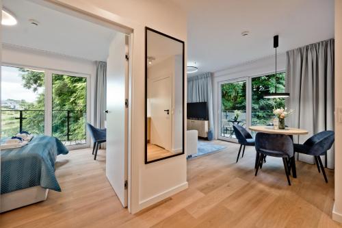 a bedroom with a bed and a table with chairs at Aparthotel Anchoria BlueApart in Mechelinki