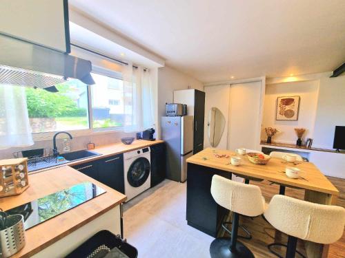 ロデーズにある# AU RUE DU GAZ - Cosy & confort proche Rodez centreのシンクとテーブルと椅子のあるキッチン