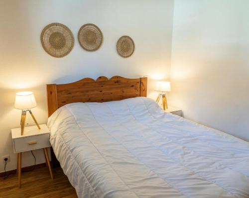 une chambre avec un lit et deux lampes au mur dans l'établissement Résidence Les Hauts De Preclaux - Appartement 4 personnes au coeur des Orres MAE-3611, aux Orres