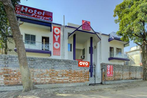 a white building with red signs in front of it at Super Hotel O Pragya New in Raipur