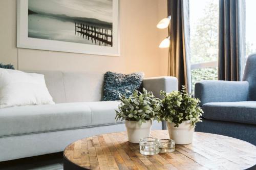 a living room with a couch and a coffee table at Mooi chalet in havenplaatsje op fietsafstand van het strand bij Ouddorp in Goedereede