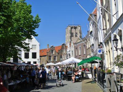 a group of people walking down a street with a market at Mooi chalet in havenplaatsje op fietsafstand van het strand bij Ouddorp in Goedereede
