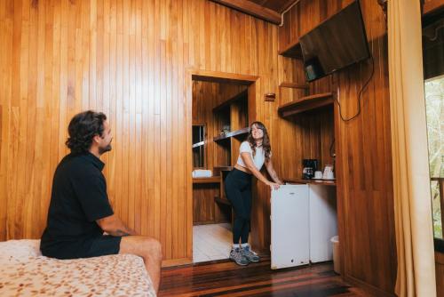 a man and a woman in a room with a woman in a kitchen at Jaguarundi Jungle Lodge - Monteverde in Monteverde Costa Rica