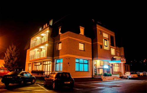 a building with cars parked in front of it at night at Hotel Damis in Pale