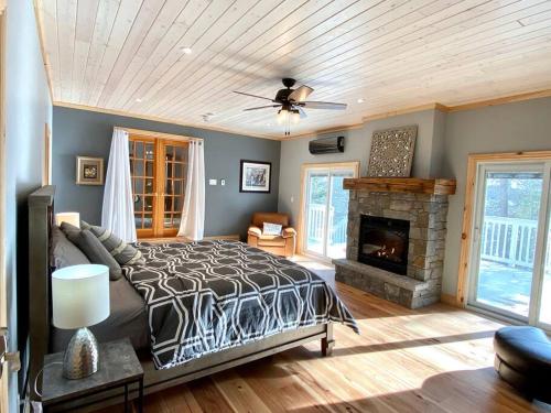sypialnia z łóżkiem i kominkiem w obiekcie Stunning All-Seasons Muskoka Lakefront Cottage w mieście Huntsville