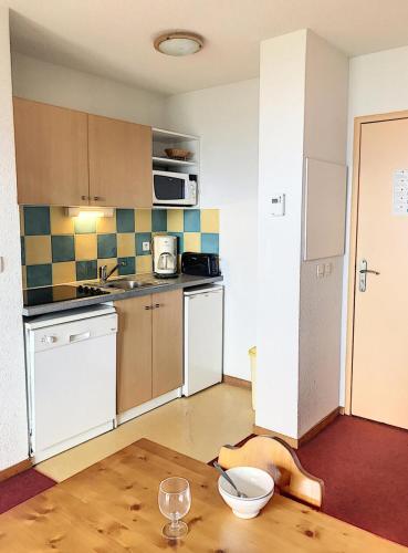 - une cuisine avec une table et un bol sur le sol dans l'établissement Résidence Pistes - APPARTEMENT 2 PIECES 4 PERSONNES MAE-9754, au Corbier