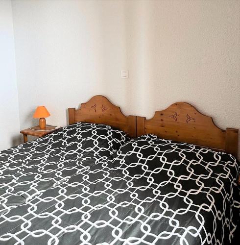 une chambre avec un lit avec une couette noire et blanche dans l'établissement Résidence Pistes - APPARTEMENT 2 PIECES 4 PERSONNES MAE-9754, au Corbier