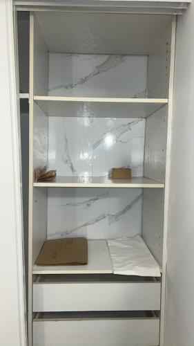 une armoire blanche avec une boîte à l'intérieur dans l'établissement Studio Relax proche de Paris et Aéroport, à Vitry-sur-Seine