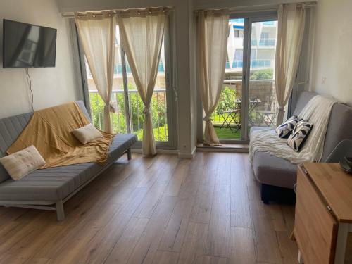 - un salon avec un canapé et du parquet dans l'établissement Le studio de Noah, 50m de la plage, wifi, à La Grande Motte