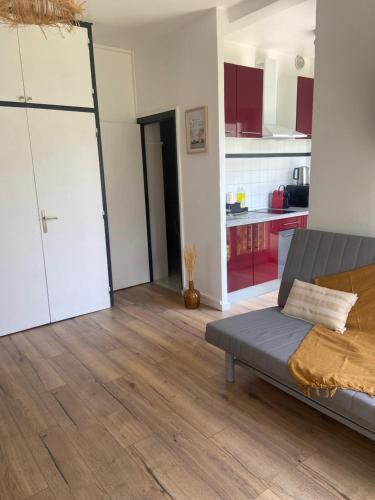 un salon avec un canapé et une cuisine dans l'établissement Le studio de Noah, 50m de la plage, wifi, à La Grande Motte