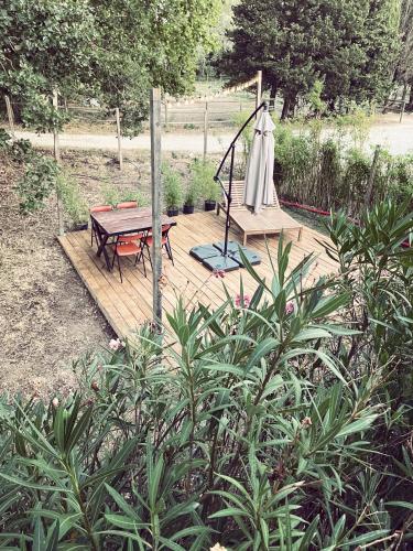 a wooden deck with a bench and a picnic table at Appartement à la campagne in LʼIsle-sur-la-Sorgue