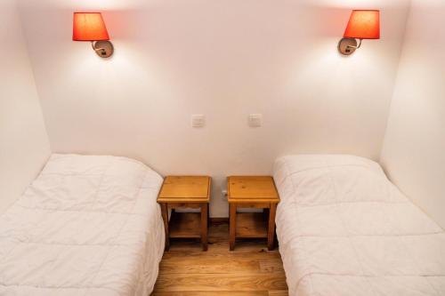 - 2 lits dans une chambre avec une table et des lumières dans l'établissement Résidence Les Hauts De Preclaux - Studio spacieux avec balcon face aux pistes MAE-3461, aux Orres