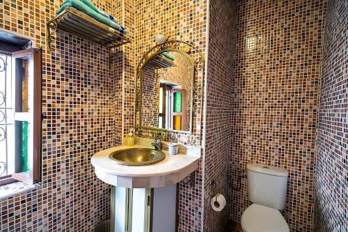 a bathroom with a sink and a toilet and a mirror at Riad Mounana fez luxurious palace & spa in Fès