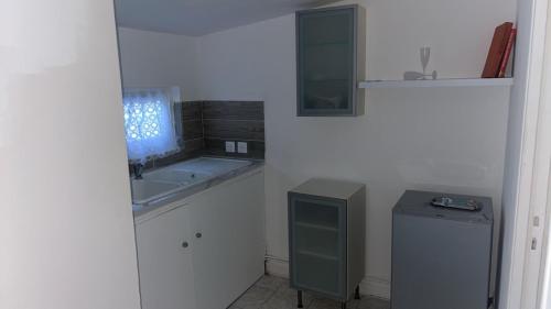 une salle de bain blanche avec un lavabo et un miroir dans l'établissement Studio Relax proche de Paris et Aéroport, à Vitry-sur-Seine